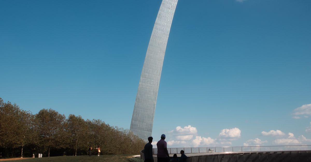 Tourists enjoy an outdoor view of the Gateway Arch in sunny St. Louis, Missouri.